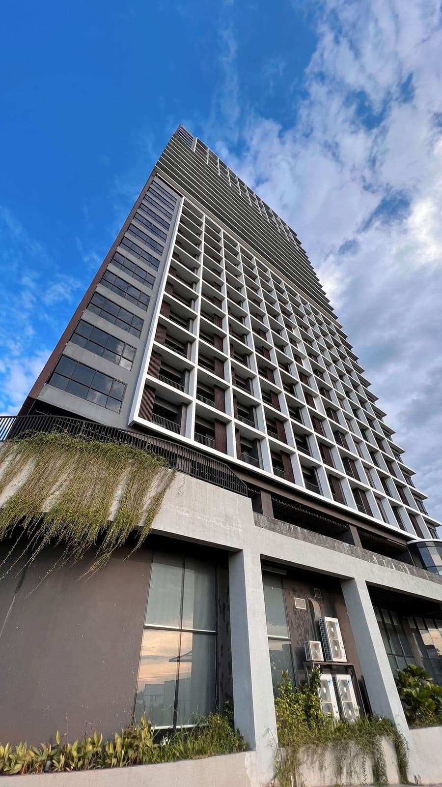 The Ayoma Residence tower seen from the street, its balconies stacked against the sky