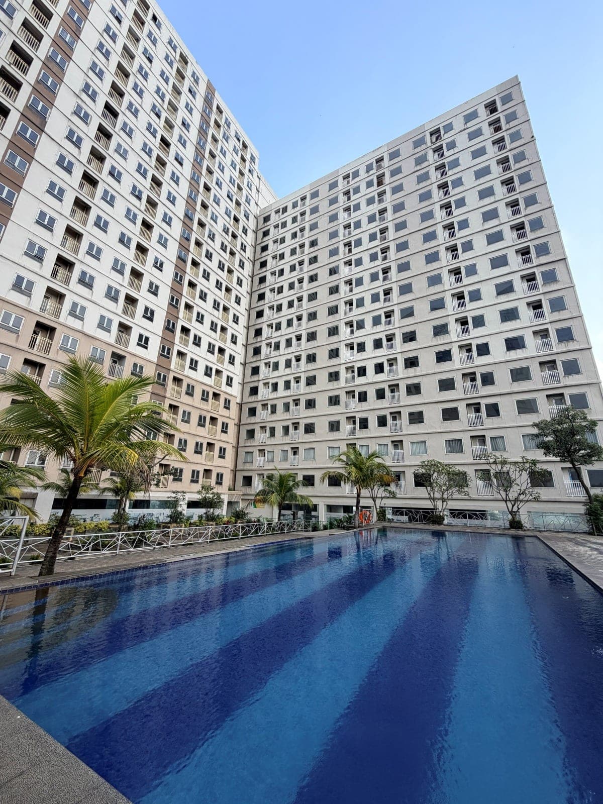 Two Titanium Square towers rising behind the swimming pool in the courtyard
